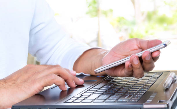 istock Businessman using his laptop computer and smartphone. 887259274