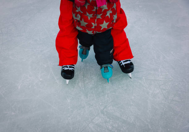 istock father and child learning to skate in winter 887262734