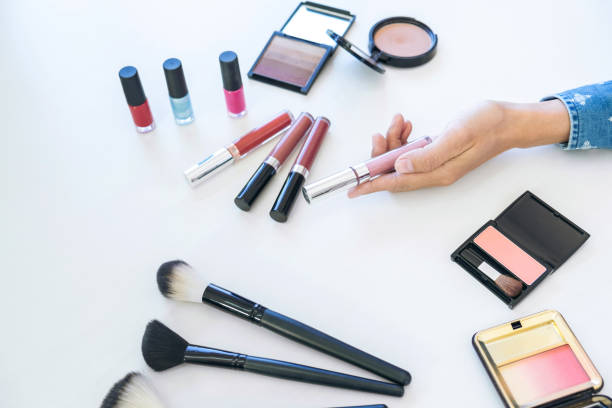 istock Many makeup cosmetics different on white wooden table background, top view 887267356