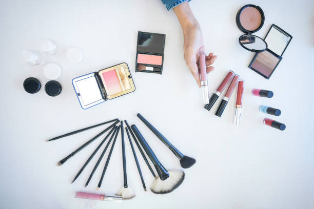 istock Many makeup cosmetics different on white wooden table background, top view 887267366