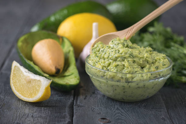 istock Spoon light wood in the bowl with the avocado cream on rustic table. 887270470