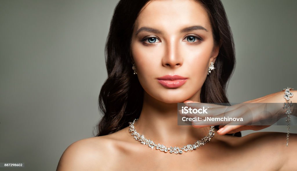 Beautiful Female Face. Young Woman with Perfect Diamond Jewelry Jewelry Stock Photo