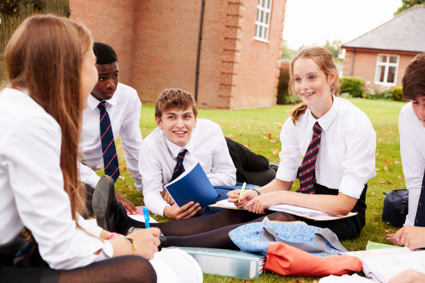 istock Teenage Students In Uniform Working On Project Outdoors 887302404