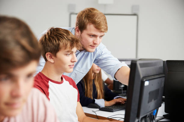 istock Teenage Students Studying In IT Class With Teacher 887302540