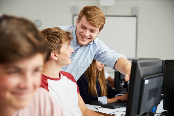 istock Teenage Students Studying In IT Class With Teacher 887302648