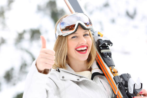 Happy skier with thumbs up in a slope Portrait of a happy skier with thumbs up in a slope with a snowy mountain in the background thumbs up for skiing stock pictures, royalty-free photos & images