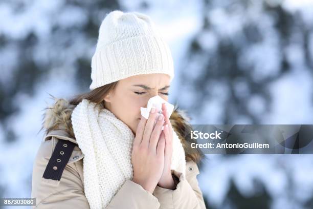 Mujer Que Sopla En Un Tejido En Un Invierno Nevado Foto de stock y más banco de imágenes de Invierno - Invierno, Resfriado y gripe, Alergia