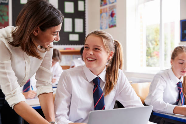 nauczycielka pomagająca uczniowi w korzystaniu z komputera w klasie - teacher computer high school student classroom zdjęcia i obrazy z banku zdjęć