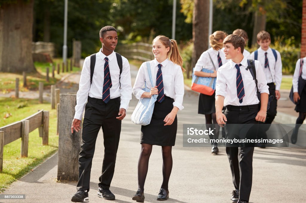 Grupo de estudiantes adolescentes en uniforme exterior edificios de escuela - Foto de stock de Educación en escuela privada libre de derechos