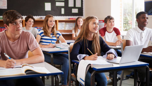 istock Students Listening To Female Teacher In Classroom 887303374