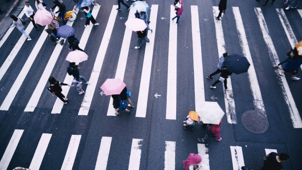 istock Pedestrian people cross a road in rainy day 887303482