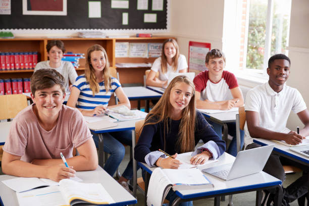 istock Portrait Of Students Sitting At Desks In Classroom 887303494
