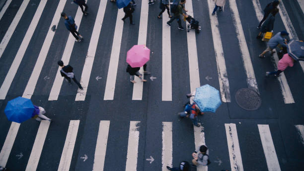 istock Pedestrian people cross a road in rainy day 887303498