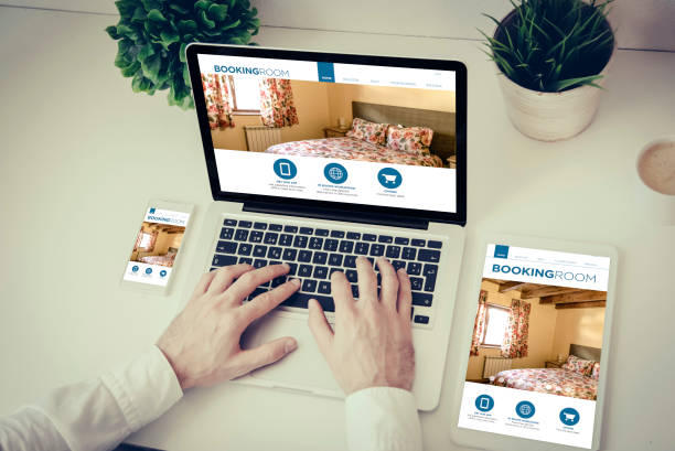 istock hands writing on a laptop with tablet and phone booking website 887307394