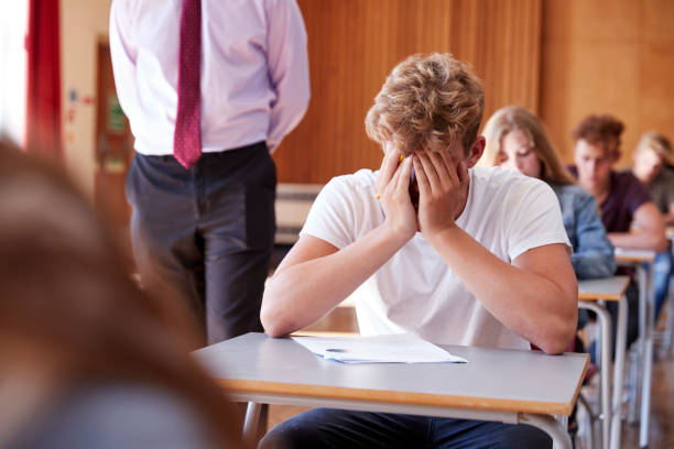 istock Anxious Teenage Student Sitting Examination In School Hall 887313568