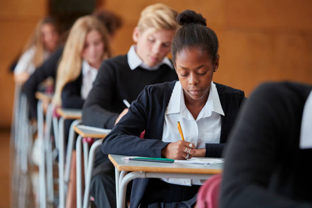 studenti adolescenti in uniforme esame di seduta in aula scolastica - educazione di scuola privata foto e immagini stock