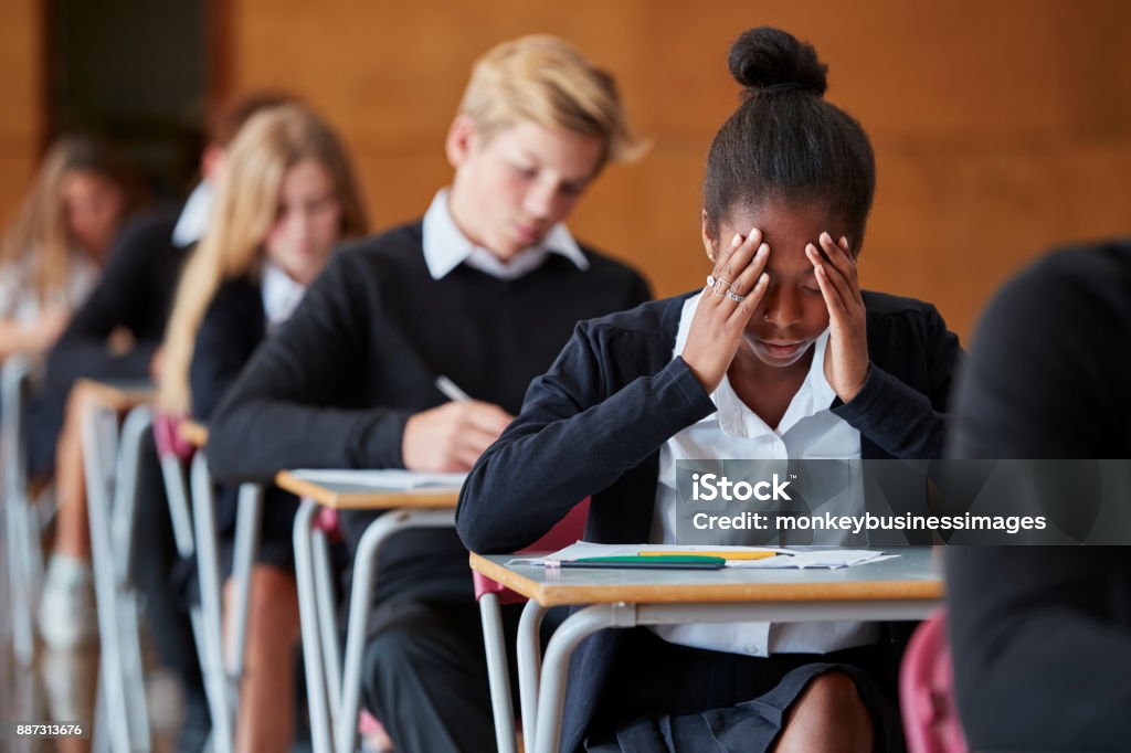 Anxieux étudiant adolescent assis examen en salle d’école - Photo de Examen libre de droits