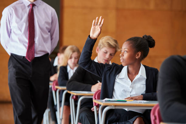 istock Teenage Student Sitting Examination Asking Teacher Question 887313748