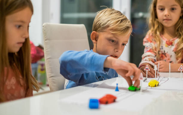 Kids playing with plastic cars at the table