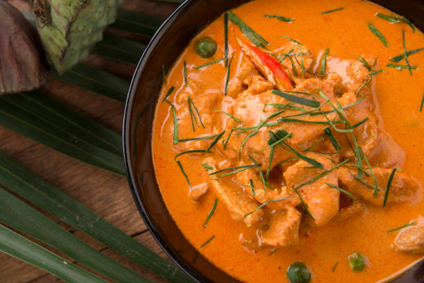 Thai curry red soup,Thailand tradition red curry with beef,pork or chicken menu in thai name is panaeng.Curry menu with coconut milk.Panaeng Curry on Wooden table stock photo