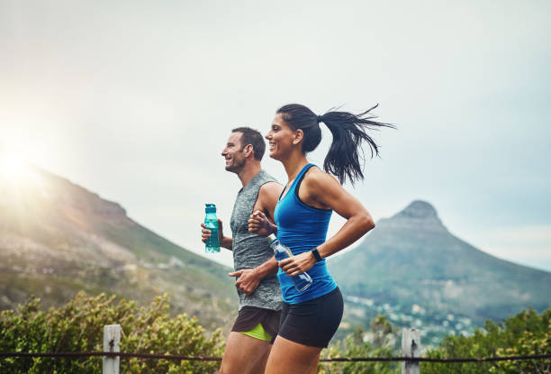 We compete in a friendly way Shot of a young attractive couple training for a marathon outdoors jogging stock pictures, royalty-free photos & images