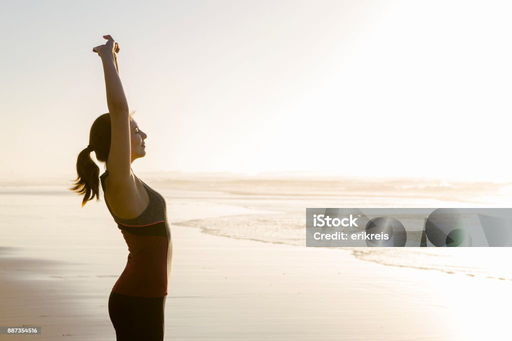 Exercise at the beach Shoot of a beautiful woman making stretching exercises in the beach Wellbeing Stock Photo