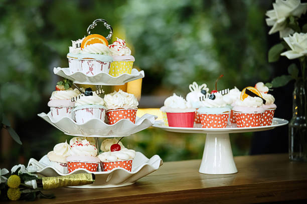 wedding colorful cupcakes pretty colorful cupcakes for wedding celebration white wedding cake red roses stock pictures, royalty-free photos & images