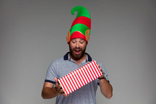 istock Happy bearded guy with Christmas Elf hat and present 887357982