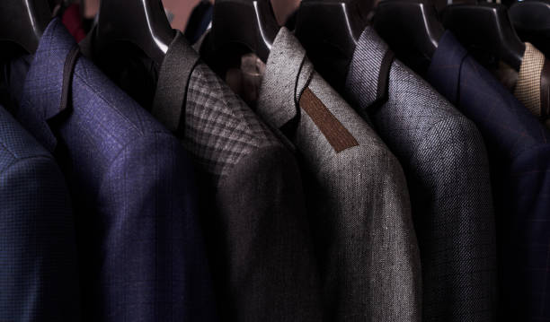 istock Mens suits on hangers in different colors 887360916
