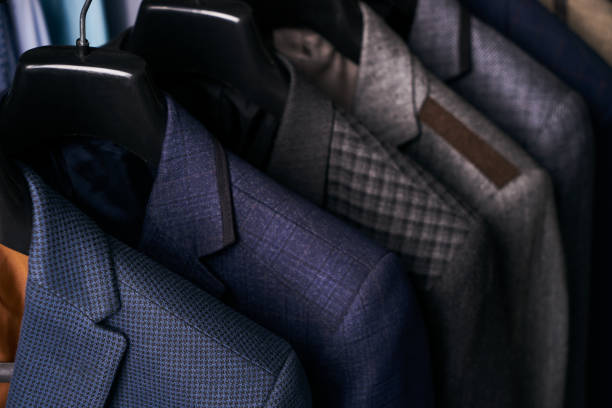 istock Mens suits on hangers in different colors 887360926