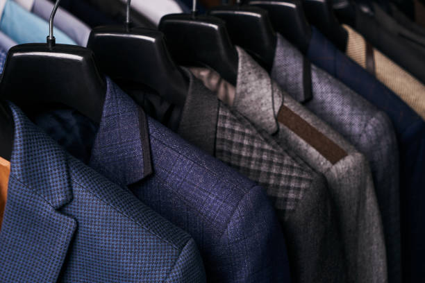 istock Mens suits on hangers in different colors 887360962