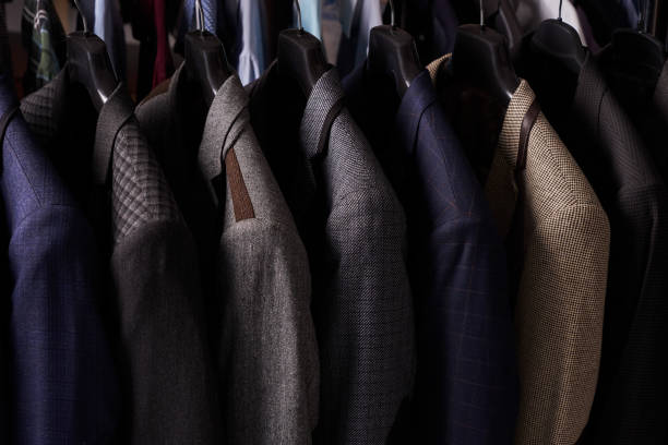 istock Mens suits on hangers in different colors 887360964