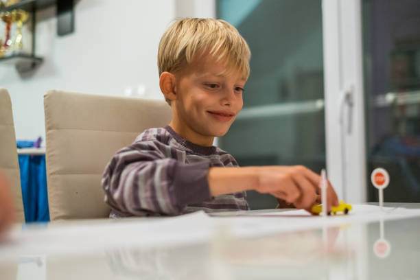istock Boy playing with plastic cars 887362112