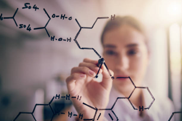 One small adjustment Shot of a focused young female scientist solving equations on a glass wall in a laboratory chemical formula photos stock pictures, royalty-free photos & images