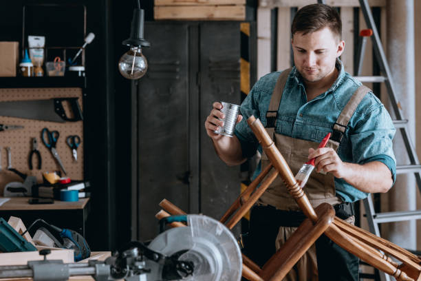 istock Smiling carpenter renovating wooden chair 887372502