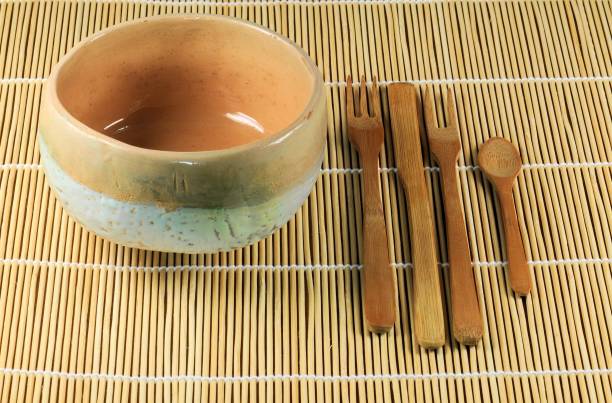 istock Japanese teacup with bamboo cutlery on vegetable mat. Spoon, two forks and a teaspoon. 887376604