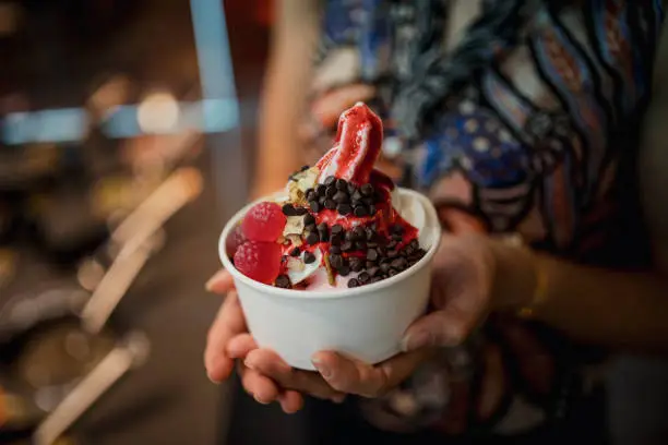 Personalised frozen yoghurt with toppings from a self service dessert bar.