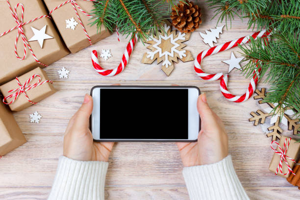 istock Woman using smartphone with blank screen, festive trumpery frame. Christmas gift search, online shopping, seasonal discounts and sale concept 887390256