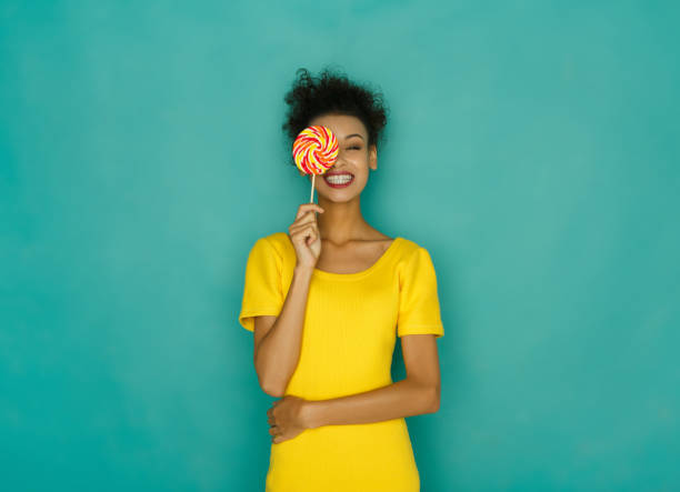 Happy girl with lollipop at studio background