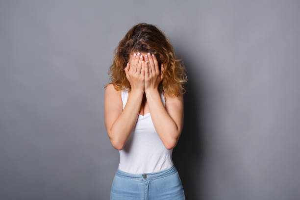 istock Young woman covering her face with palms 887394794