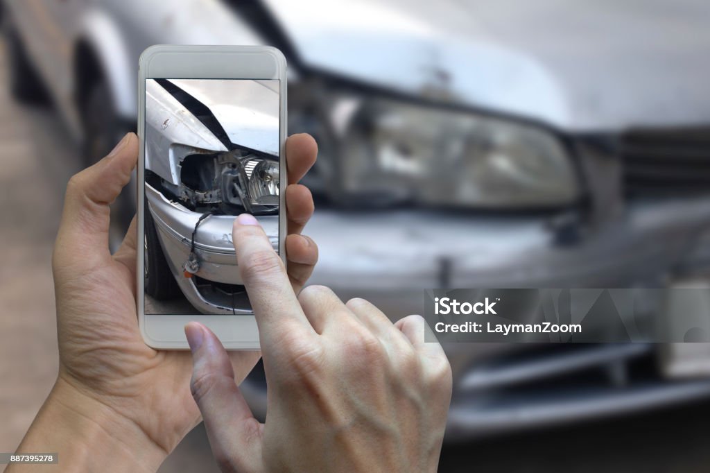 Hand holding smart phone take a photo at The scene of a car crash, car accident for insurance Hand holding smart phone take a photo at The scene of a car crash, car accident for insurance. Car Accident Stock Photo