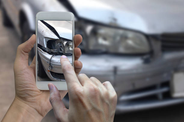 mão segurando o telefone inteligente tirar uma foto na cena de um acidente de carro, acidente de carro para o seguro - insurance claim fotos - fotografias e filmes do acervo