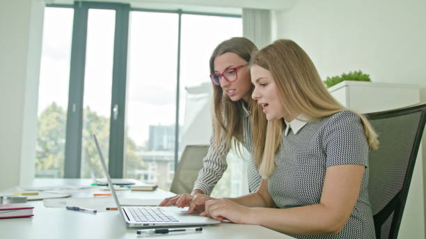 istock Two Woman Discussing Ideas Using Laptop 887395766