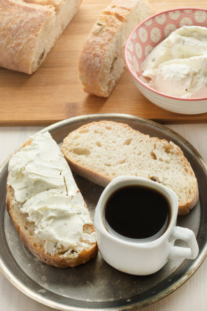 istock Delicious breakfast with bread spread on soft curds and coffee. A sandwich with butter and cheese. Ciabatta chopped. 887406684