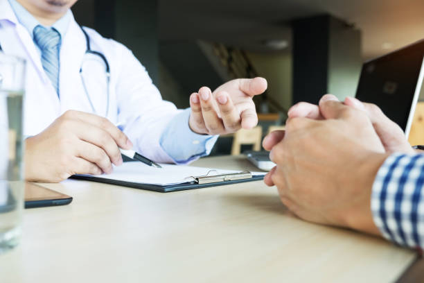 istock Midsection Of Doctor Explaining Patient At Table In Clinic 887407770