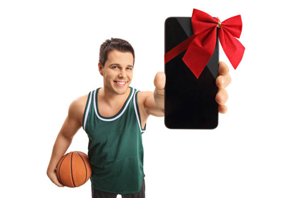 istock Basketball player showing a phone wrapped with a red ribbon as a gift 887407850