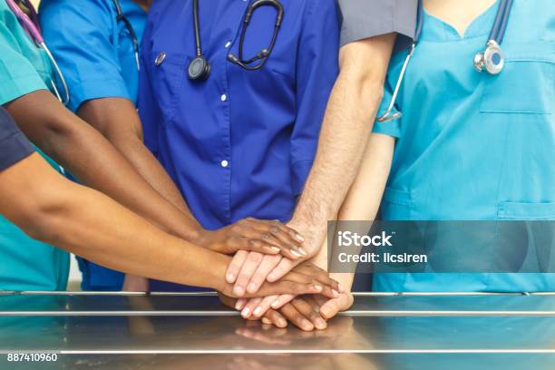Multiracial Team Of Young Doctors Stacking Hands Indoor Group Of Multiracial Doctor Surgery Team Stacking Hands In A Operating Room Medical Teamwork Stock Photo - Download Image Now