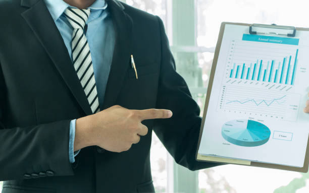 istock A side view of a businessman analyzing a series of graphs with colleagues while meeting summaries of sales and holding a map with statistics in hand. 887424404