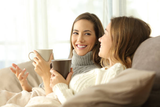 istock Two roommates talking on couch in winter 887430290