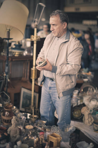 istock Man is visiting market of old things, choosing old casket 887436462